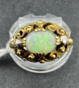 Jewellery: Yellow metal ring set with a 7mm x 5mm oval cabochon-cut opal with a rose-cut diamond eit