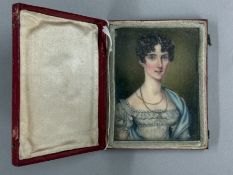 Decorative Arts; a watercolour on ivory of a young girl in formal blue dress, the leather case detai