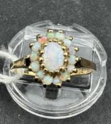 Jewellery: a 9ct gold ring in the form of an oval cluster set with fifteen opals, size of ring N, we