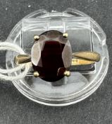 Jewellery: 9ct gold ring, claw set with an 8.5mm x 7mm oval-cut garnet, hallmarked Birmingham 1985, 