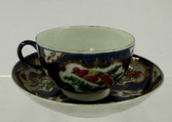 A Worcester tea cup and saucer, c.1760-65, painted with panels of colourful exotic birds within gilt