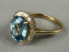 Jewellery: a yellow metal ring, marked 10k and testing as gold, set a central blue topaz within a ha