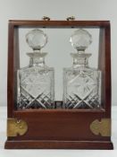 Decorative Arts: Mahogany double Tantalus with brass fittings, two cut glass whisky decanters with s