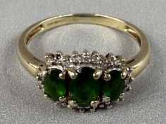Jewellery: a 9ct yellow gold ring set with three graduated chrome diopside within a framework of dia