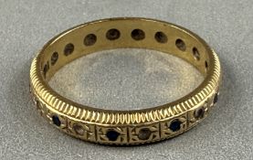 Jewellery: an 18ct yellow gold full eternity ring, set with alternating blue and white sapphires, UK