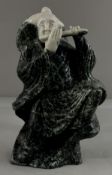 A Chinese hardstone carving of a musician, the figure standing and playing the flute with one foot r