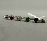 Jewellery: a white metal bar brooch, unmarked but testing as 9ct gold, claw set with a sapphire, an 