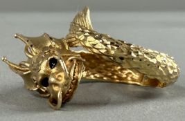 Jewellery: a yellow metal ring in the form of a dragon, the band engraved to simulate scales, the he