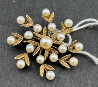 Jewellery: a 9ct gold mistletoe style brooch, a central pearl within two circles of smaller pearls, 