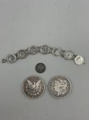 Coins: a 1902 US Morgan silver dollar, Philadelphia mint, another, a 1904 4d coin and a 1930s 3d coi