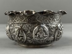 Silver: an Indian white metal temple bowl, a crimped everted rim above a body chased and embossed wi