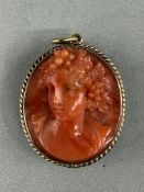 Jewellery: Yellow metal oval pendant 30.5mm x 26mm, one side set with a coral cameo, the other with 