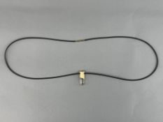 Jewellery: a yellow metal mounted rock crystal pendant, marked 750 and testing as gold, on a leather