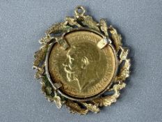 Coins: a 1925 George V half sovereign, circulated, in 9ct gold laurel wreath mount, total weight 7.2