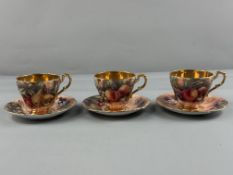 Three English porcelain cups and saucers, 20th century, painted by David Bowkett with arrangements o