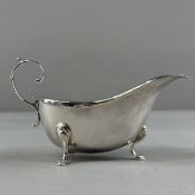 Silver: a sauceboat, crenellated rim and standing upon three hoof feet, flying scroll handle, hallma