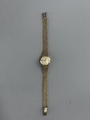 Watches: a ladies 9ct gold Omega automatic wristwatch on integral trelliswork style strap, London 19