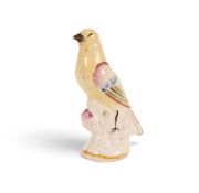 A Staffordshire figure of a canary, 1st half 19th century, perched on a low stump, the wings and tai