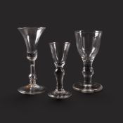 A small baluster gin glass and two wine glasses, c.1725-40, the gin with a round funnel bowl raised