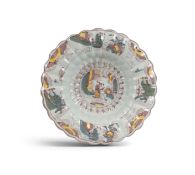 A large and early fluted Delft dish, c.1690-1700, painted in manganese, yellow, blue and green with 