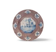 A Wincanton delftware plate, c.1740, the well painted in blue with an octagonal panel of boats saili