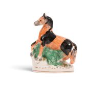 A Staffordshire figure of a horse, 19th century, modelled with its right foreleg raised, decorated w