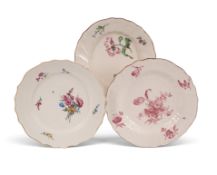 Three Tournai plates, c.1755-70, one early and painted with a loose poppy, the moulded rim with four