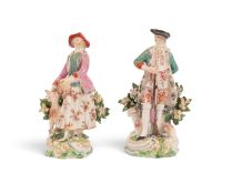 A pair of Derby figures of a hunter and his companion, c.1765, each modelled with a large dog, he ho