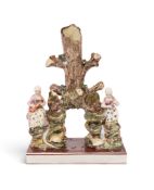 A large Staffordshire pearlware spill vase figure group, c.1800, modelled as a tree trunk rising fro