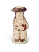 A creamware Toby jug of Ralph Wood type, c.1785-90, seated with a foaming jug of ale and wearing a s