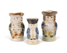 Three miniature standing Toby jugs, c.1800, each holding a bottle and a glass clutched to their expa