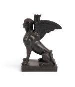 A Wedgwood black basalt sphinx candlestick, early 19th century, seated on its haunches and wearing a
