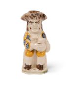 A Pratt ware Toby jug and cover, c.1800-10, of Ordinary type, wearing an elaborately patterned coat 