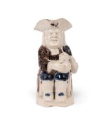 A pearlware Toby jug, c.1780-90, of Ordinary type, seated with a foaming jug of ale on his left knee