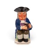 A rare marked Leeds Pottery Toby jug, c.1820, wearing a blue coat over a purple patterned waistcoat,