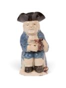 A creamware 'Step' Toby jug, c.1780-85, seated with an empty manganese jug and a long-stemmed clay p