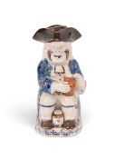 A pearlware Toby jug and cup with 'Collier' type base, c.1790, seated with a foaming jug of ale and 