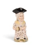 A Martha Gunn Toby jug, c.1820, seated with a foaming jug and a glass, wearing a patterned dress and