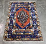 A BLUE GROUND TRIBAL RUG (160 x 115CM)