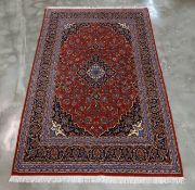 A FINE PERSIAN RED GROUND MEDALLION WOOL RUG (240 x 140CM)