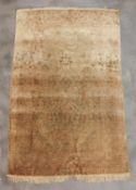 A SIGNED CREAM GROUND MEDALLION SILK RUG (123 x 75CM)