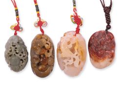 A GROUP OF FOUR CARVED HARDSTONE PENDANTS