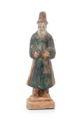 A GREEN AND YELLOW GLAZED POTTERY FIGURE OF A MUSICIAN