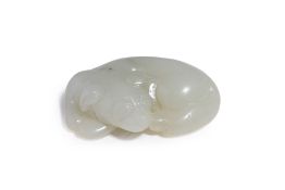 A WHITE JADE CARVING OF A RECUMBENT DOG