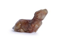 A CELADON AND RUSSET JADE CARVING OF A DEER