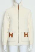 HERMÈS - A VIRGIN WOOL KNIT ZIP UP JACKET WITH LEATHER 'H' LOGO POCKET DETAILS