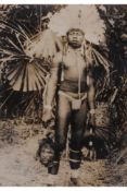 A PHOTOGRAPHIC PRINT OF A NEW GUINEA HEADHUNTER