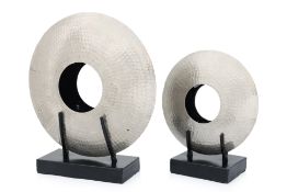 A GRADUATED PAIR OF HAMMERED METAL DISCS