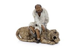 A SHIWAN POTTERY FIGURE OF A LUOHAN TAMING A TIGER