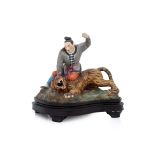 A PORCELAIN MODEL OF A MAN SUBDUING A TIGER
